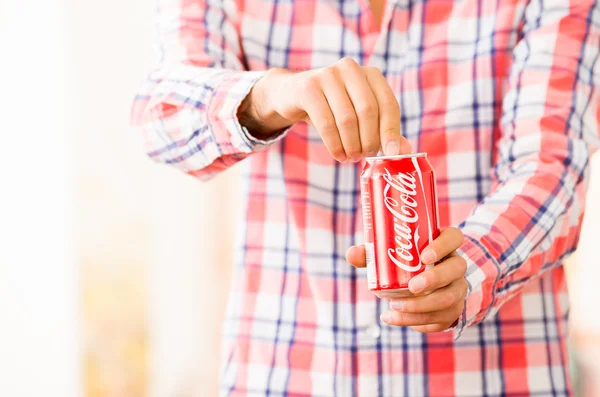 Gros plan de mains de jeune homme ouvrant une boîte de Coca-Cola — Photo