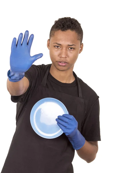 Jeune homme hispanique portant des gants de nettoyage bleus et tenant une plaque turquoise tandis qu'avec l'autre main faisant symbole d'arrêt — Photo