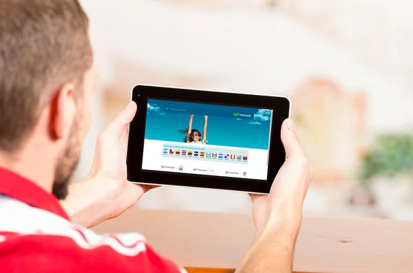 Young man using tablet computer looking at movistar website latin america — Stock Photo, Image