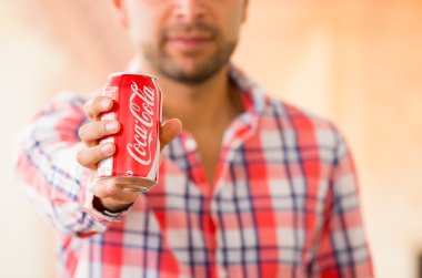 Closeup of young man holding a Coca-Cola can