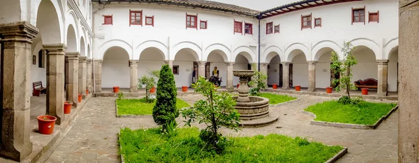 Patio trasero de la iglesia de San Diego mostrando un pequeño y acogedor jardín con plantas verdes y fuente de piedra de estilo colonial típico español —  Fotos de Stock