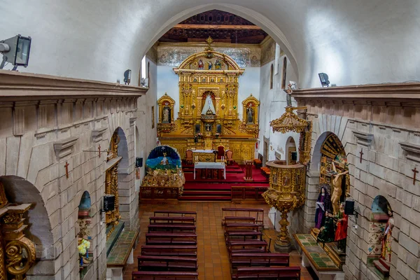 Uvnitř San Diego kostela zobrazení Perspektiva z hlavní místnosti s kamennými zdmi, dřevěnými lavicemi a změnit na konci, kolem kresby umístěno velké náboženské dekorem ve zlaté barvě — Stock fotografie