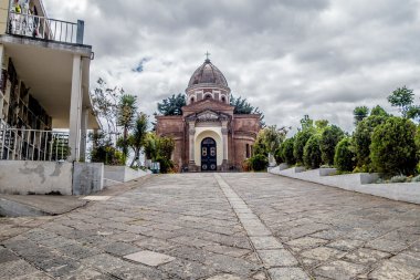 Beautiful San Diego church dome view from cemetary showing stone path leading up to building with green trees and nice blue sky