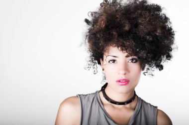 Headshot brunette hispanic model afro like hair dark eyes black necklace posing for camera