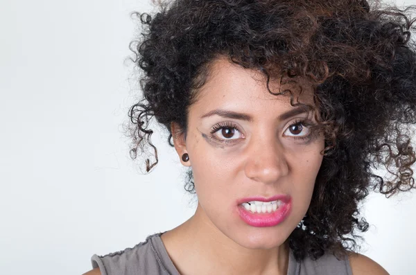 Headshot hispanic brunette model with messy makeup and hair looking angrily into camera, white background — 图库照片