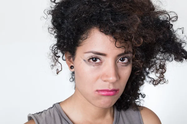 Cabeza hispana modelo morena con maquillaje desordenado y el pelo mirando triste en la cámara, fondo blanco —  Fotos de Stock