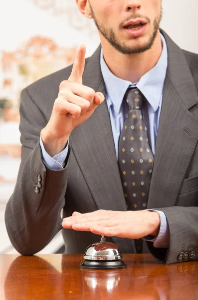 Customer ringing hotel bell at reception desk — Stock Photo, Image