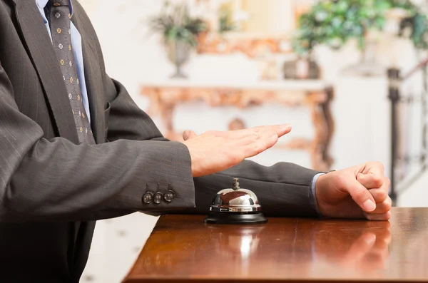 Customer ringing hotel bell at reception desk — Stock Photo, Image