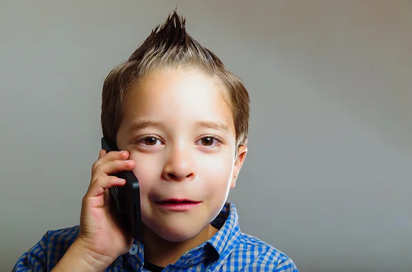 Солодкий маленький хлопчик розмовляє за допомогою мобільного телефону — стокове фото
