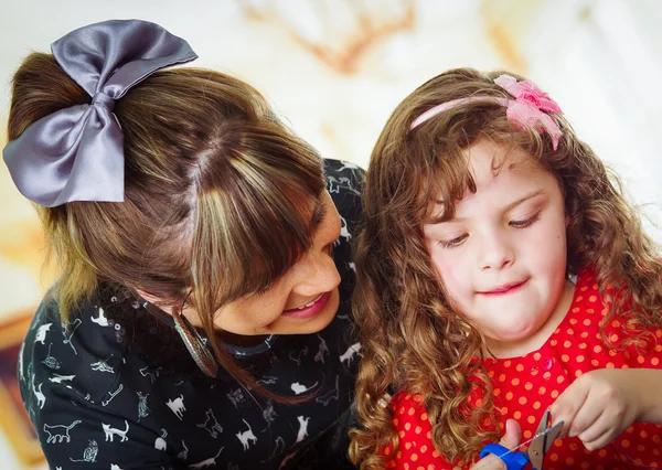 Madre ayudando a niña cortada con tijeras — Foto de Stock