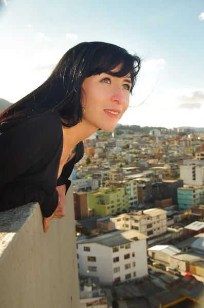 Beautiful young happy girl contemplating the city from a terrace — Stock Photo, Image