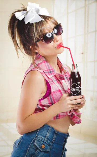 Bella ragazza retrò in possesso di una vecchia bottiglia di coca cola vintage — Foto Stock