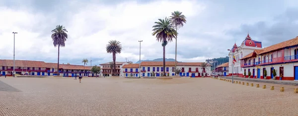 Vista panorâmica, centro histórico da cidade Zipaquira, onde está localizada a Catedral de Diocesana cercada por bela arquitetura vermelha e azul com palmeiras . — Fotografia de Stock