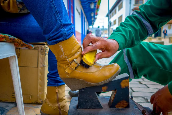 Vértes a shoeshiner dolgozik sárga csizma a központban, történelmi Zipaquira City, Közép-Kolumbia található, 48 km Bogota. — Stock Fotó