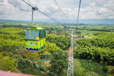 NATIONAL COFFEE PARK, COLOMBIA, Downward view of green cable car descending by, inside National Coffe Park, shot from passenger perspective