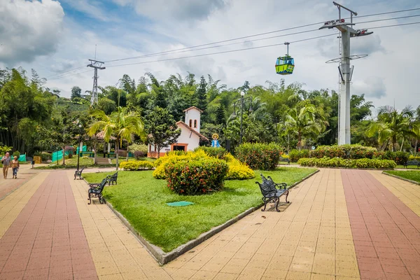 Národní Park kávy, Kolumbie, pěkná cesta udržované zelené zahrady uvnitř národního parku kávu s lanovkou viditelné procházející přes cestu — Stock fotografie