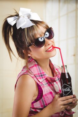 Eski bir vintage coca cola şişe tutan güzel retro kız