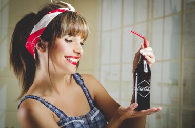 Eski bir vintage coca cola şişe tutan güzel retro kız