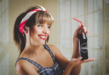 Eski bir vintage coca cola şişe tutan güzel retro kız