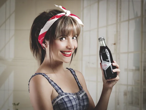 Beautiful retro girl holding an old vintage coca cola bottle — Stock Photo, Image