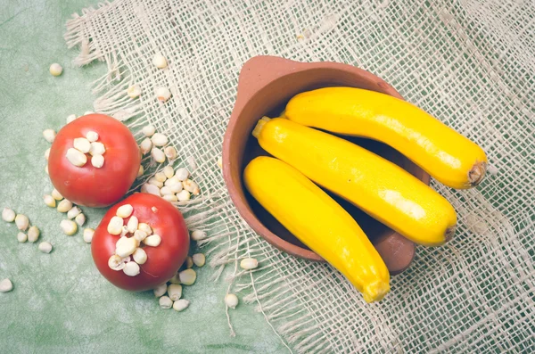 Aromatic garden-fresh zucchinis displayed in ceramic terracota bowl with corn and tomatoes — Stock Photo, Image