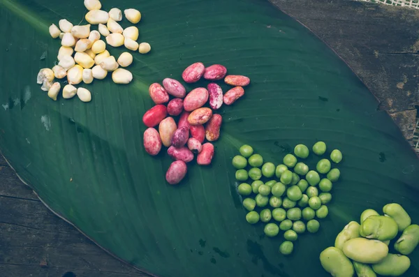 Haricots rouges de maïs cru, pois verts et haricots de lima biologiques délicieux sur une feuille — Photo