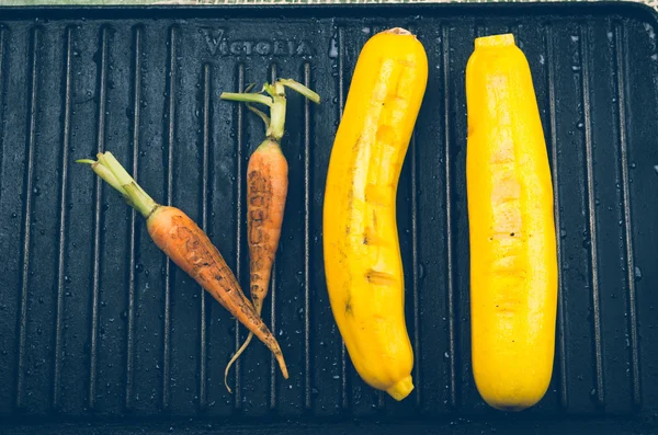 Vollnatürliche Karotten und Zucchini auf schwarzem Metallgrill — Stockfoto