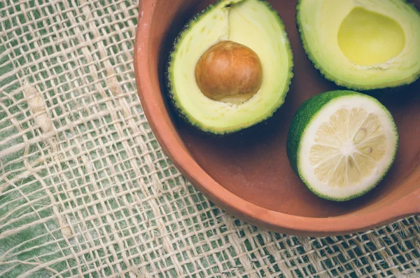 Fresh ripe avocados and lime in bowl — Stockfoto