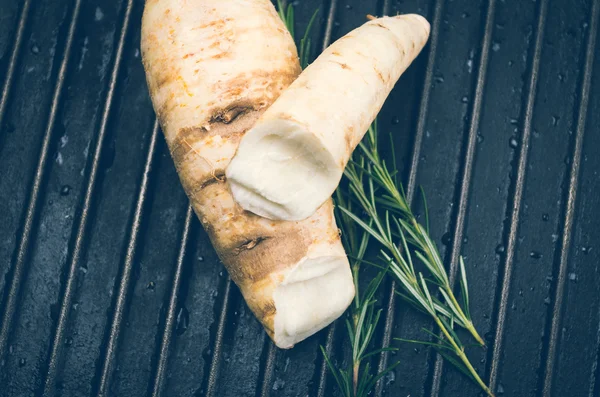 White carrot and rosemary on metal black background — Stock Photo, Image
