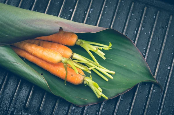 Bio-und leckere Karotten in grünem Blatt auf Metallgrill Hintergrund — Stockfoto