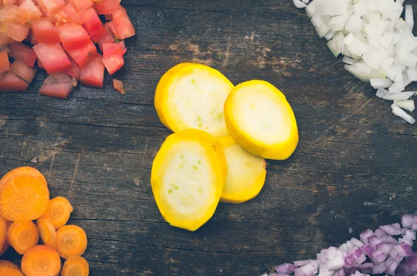 Zucchine mature fresche, carote, pomodori, cipolla tagliata su una tavola di legno e sparata dall'alto — Foto Stock