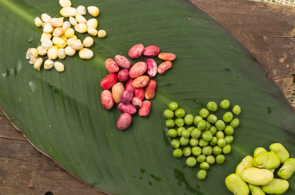 Haricots rouges de maïs cru, pois verts et haricots de lima biologiques délicieux sur une feuille — Photo