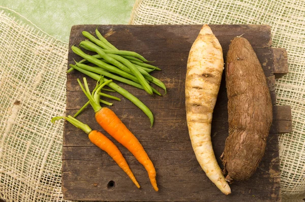 Délicieuses carottes, haricots, carotte blanche et patate douce sur bois — Photo