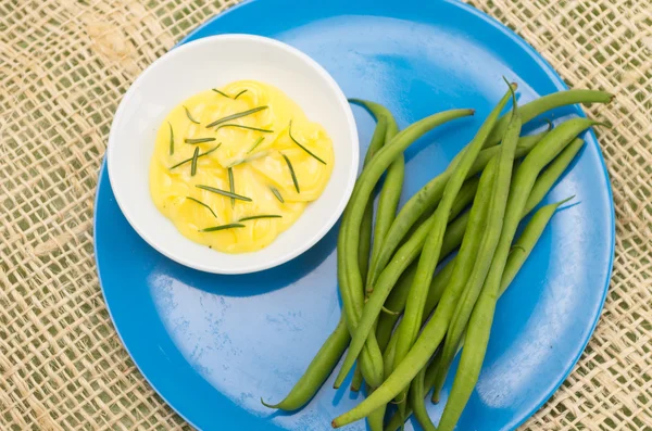 Blauw bord met boter rozemarijn en groene bonen — Stockfoto