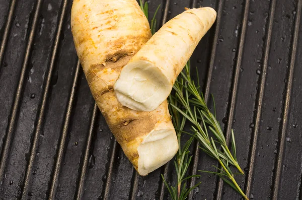 White carrot and rosemary on metal black — Stock Photo, Image