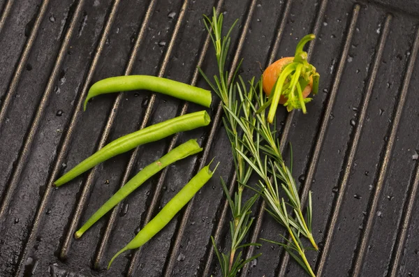 Marchew organiczny w zielonych liści na metalu grill — Zdjęcie stockowe