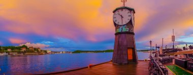 OSLO, NORWAY - 8 JULY, 2015: Charming small clocktower located at Aker Brygge pier during sunset hour