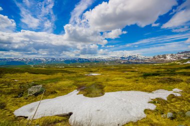 Valdres, Norveç - 6 Temmuz, 2015: kaplı doğa Valdresflya, yeşil peyzaj çarpıcı uzanan çok göz benekli kar, göllerin güzel mavi gökyüzü altında görebilirsiniz
