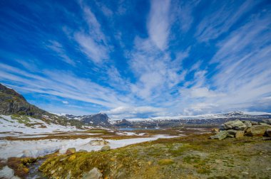 Valdres, Norveç - 6 Temmuz, 2015: kaplı doğa Valdresflya, yeşil peyzaj çarpıcı uzanan çok göz benekli kar, göllerin güzel mavi gökyüzü altında görebilirsiniz