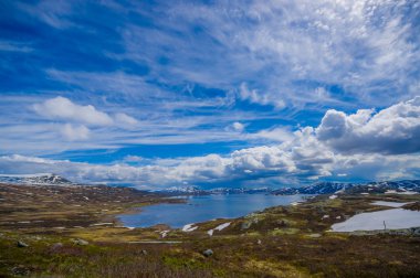 Valdres, Norveç - 6 Temmuz, 2015: kaplı doğa Valdresflya, yeşil peyzaj çarpıcı uzanan çok göz benekli kar, göllerin güzel mavi gökyüzü altında görebilirsiniz