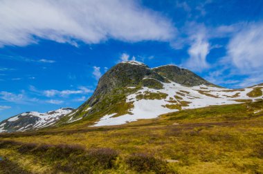 Valdres, Norveç - 6 Temmuz, 2015: kaplı doğa Valdresflya, yeşil peyzaj çarpıcı uzanan çok göz benekli kar, göllerin güzel mavi gökyüzü altında görebilirsiniz