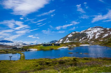 Valdres, Norveç - 6 Temmuz, 2015: kaplı doğa Valdresflya, yeşil peyzaj çarpıcı uzanan çok göz benekli kar, göllerin güzel mavi gökyüzü altında görebilirsiniz