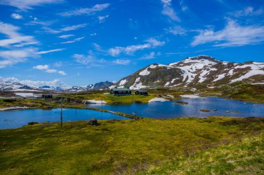 Valdres, Norveç - 6 Temmuz, 2015: kaplı doğa Valdresflya, yeşil peyzaj çarpıcı uzanan çok göz benekli kar, göllerin güzel mavi gökyüzü altında görebilirsiniz