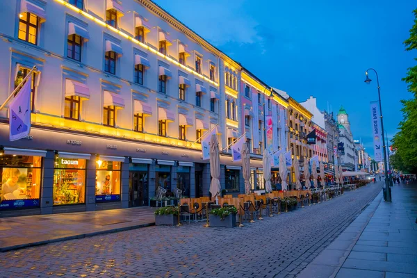 OSLO, NORUEGA - 8 DE JULIO DE 2015: Famosa calle Karl Johan durante la hora del atardecer, mostrando la librería y el área de restaurantes al aire libre —  Fotos de Stock