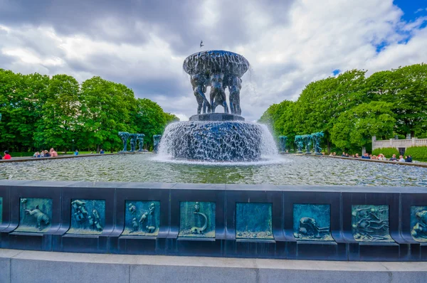 OSLO, NORWAY - 8 JULY, 2015: Big beautiful waterfall fountain located in Vigelandsparken sorrounded by charming pathways and green vegetation — Stock Fotó