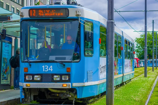 OSLO, NORUEGA - 8 JULHO, 2015: Um bonde que pega passageiros como parte do sistema de transporte público com trilhos de grama verde triste — Fotografia de Stock