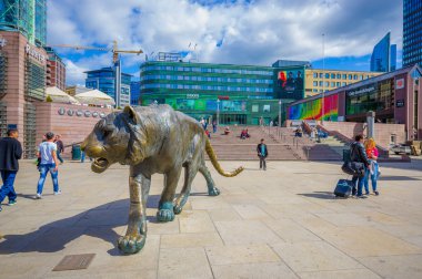 OSLO, NORWAY - 8 JULY, 2015: Plaza in front of Oslo Central station with people around and cool tiger statue on nice sunny day