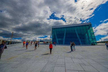 OSLO, NORWAY - 8 JULY, 2015: Walking on the spectacular opera house building located waterfront eastside of city with beautiful architecture and views 
