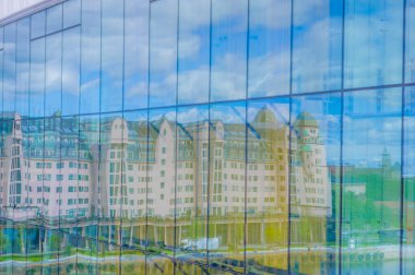 OSLO, NORWAY - 8 JULY, 2015: Reflection of beautiful typical european architecture pink office building on the waterfront, famous national newspaper Dagbladet has its offices here.