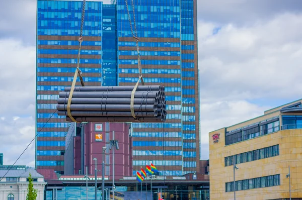 OSLO, NORWAY - 8 JULY, 2015: Bundles construction pipes get lifted up by crane in front of central station — Zdjęcie stockowe